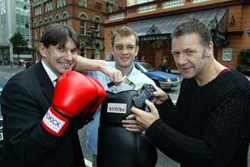 Boxing men help out for the Sun's kickboxing competition - Promoter  Paul McCausland (left) along with Neil Sinclair former British champion (centre) draw the winner as Billy Murray plays the PS2