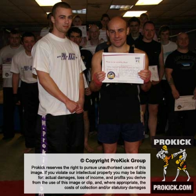 Prokicks Shankill Kickboxing instructor Barrie Oliver with Carrickfergus' new yellow belt David Mitchell