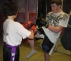 One of ProKick's beginner kickboxing enthusiasts working hard with a member of the senior class.
