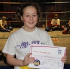 New ProKick Junior Orange Belt Caitlin Wilkinson smiling with pride after a hard grading day at ProKick HQ