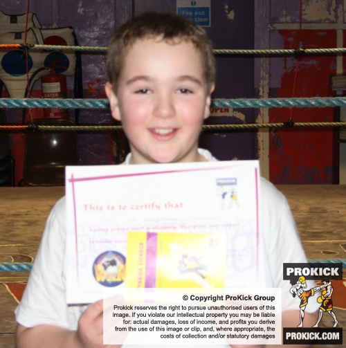 New ProKick Junior Green Belt Tyler Graham smiling with pride after a hard grading day at ProKick HQ