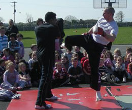 Ken Horan kicks the pads as training partner Robbie holds - Ken demonstrated and then invited some of the kids to try it for themselves.