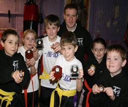 Some of the yellow belt medal winners from the ProKick Says Kickboxing Fun Day along with assistant instructor Gary Fullerton